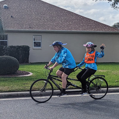 Carol Kitchen and her husband riding a tandem bicycle
